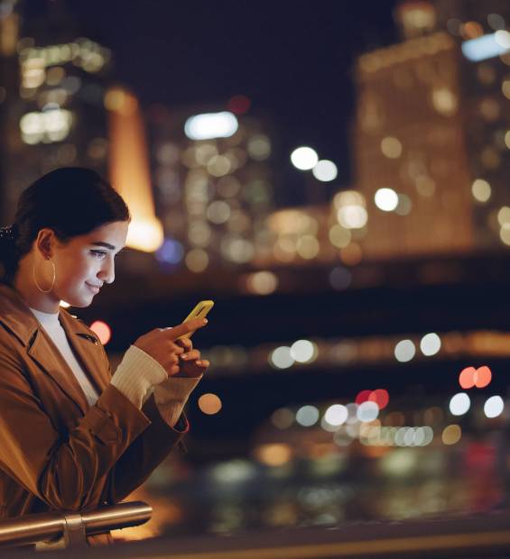 young brunette girl standing at night by Chicago skyline